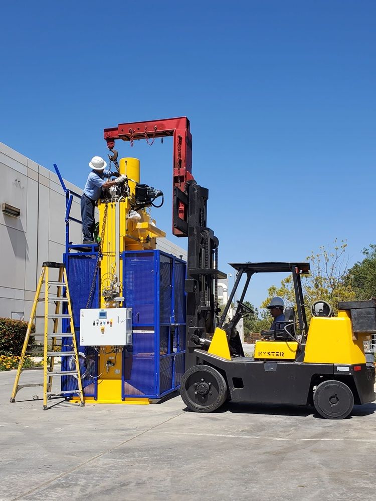 Heavy industrial machinery being moved with a forklift by experienced machinery movers at an industrial facility